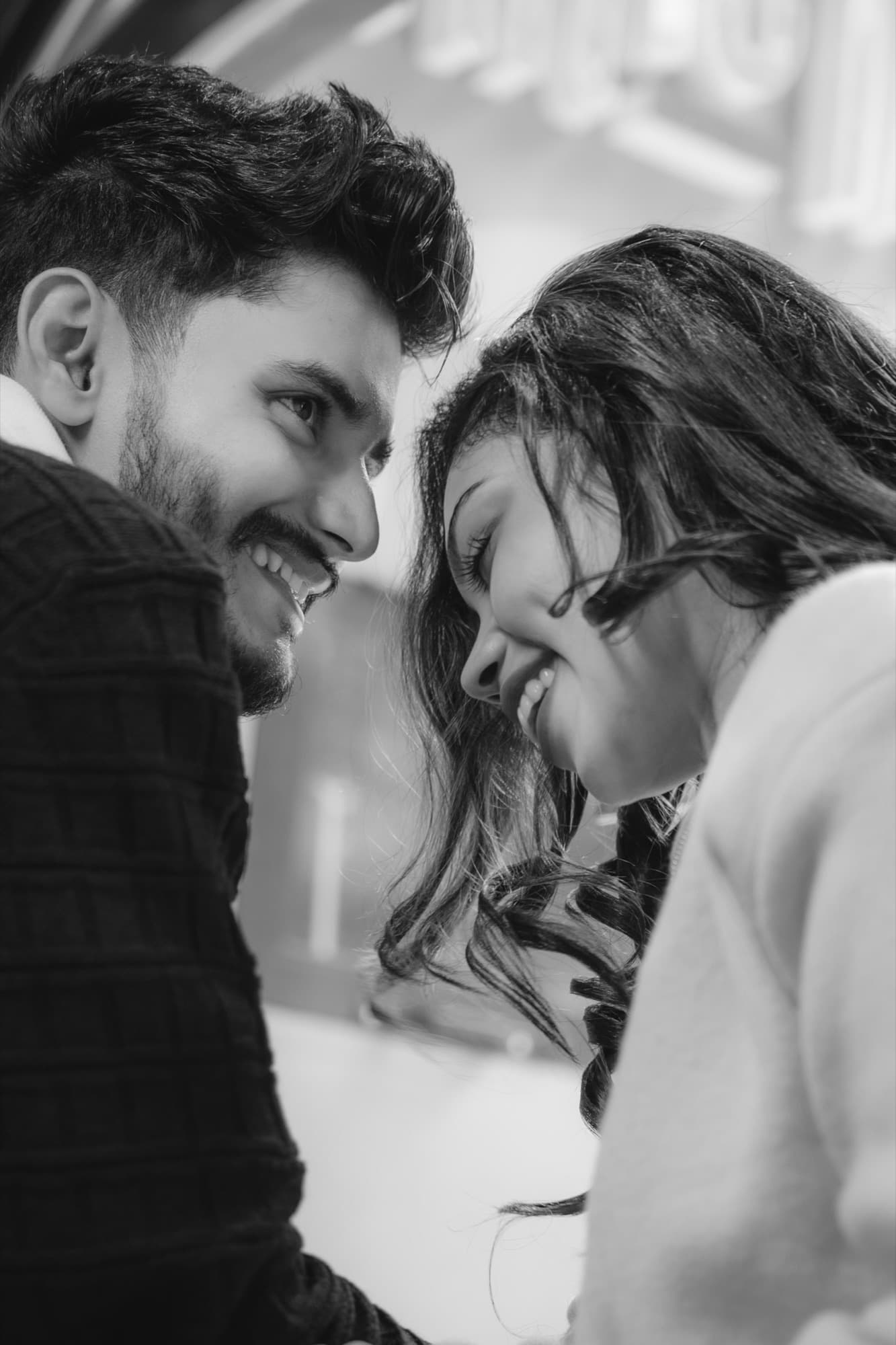 Intimate black-and-white close-up of the couple smiling with foreheads almost touching